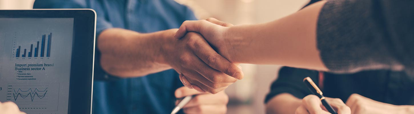 Two people shake hands after agreeing to a deal